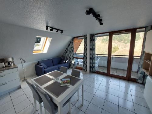 a living room with a table and a blue couch at Appartement T2 45m² avec terrasse - 4/6 personnes in Le Mont-Dore