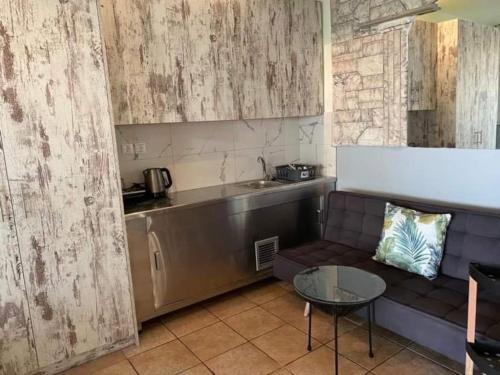 uma sala de estar com um sofá, uma mesa e uma cozinha em Athens Victoria's Apartment em Atenas