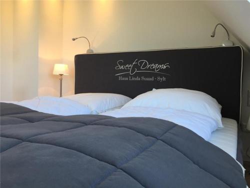 a bedroom with two beds with a black headboard at Haus-Seestern in Tinnum