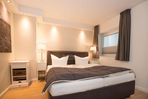 a bedroom with a large bed and a window at Haus-Seestern in Tinnum