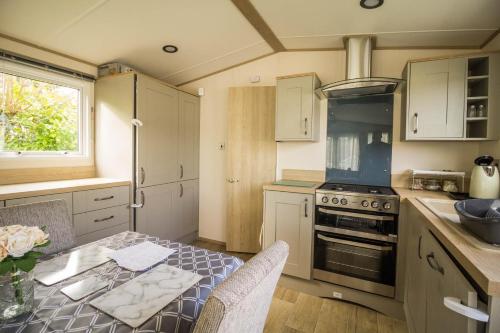 Kuchyň nebo kuchyňský kout v ubytování Beautiful Caravan With Decking At Breydon Water Holiday Park Ref 10028cw