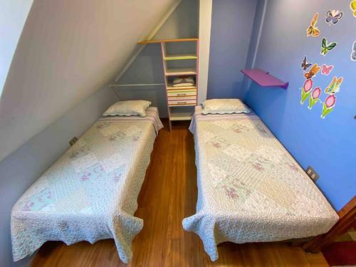 two beds in a room with a staircase at Casa céntrica por día en Pucón in Pucón