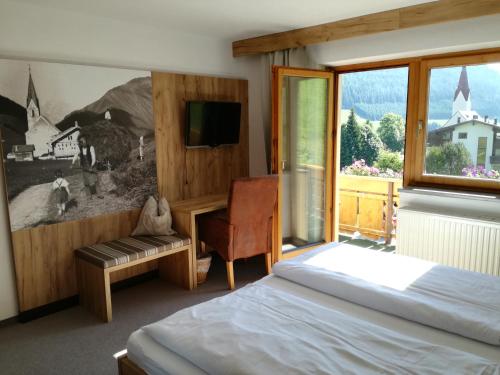 um quarto com uma cama e uma janela em Haus Alpina em Berwang