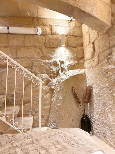 a stone wall with a staircase in a room at MCC Argotti House in Il-Furjana