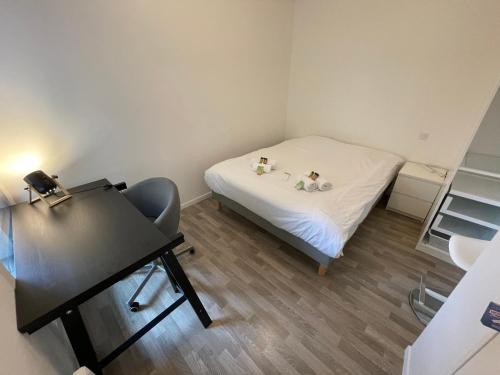um pequeno quarto com uma cama e uma secretária em Gredi YourHostHelper em Caen