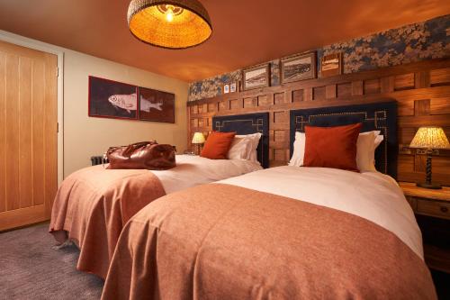 a bedroom with two beds with a dog laying on them at Harbour Inn in Porthleven