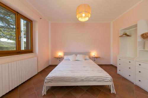 a bedroom with a bed with two lamps and a window at Al posto giusto - appartamento Sole in Riotorto