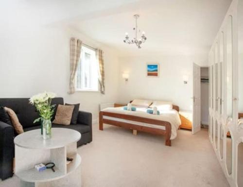 uma sala de estar com um sofá e uma cama em 3 Bedroom Bungalow with great Sea Views, Private Hot Tub & Gardens em Paignton