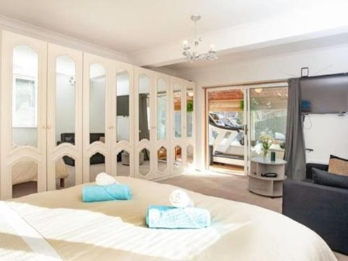a bedroom with a large white bed and a couch at 3 Bedroom Bungalow with great Sea Views, Private Hot Tub & Gardens in Paignton