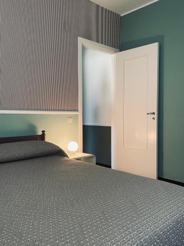 - une chambre avec un lit et une porte blanche dans l'établissement Un Angolo di Design, à Sori