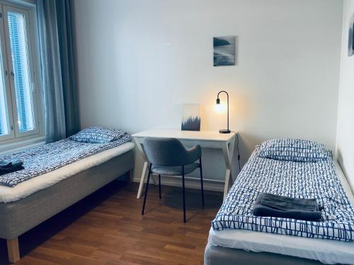 a bedroom with a desk and a bed and a chair at STAY Matinkylä Apartments in Espoo