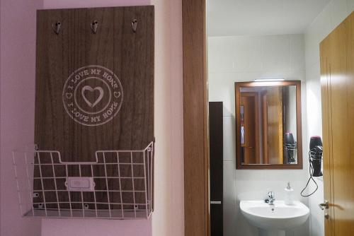 a bathroom with a sink and a sign on the door at Apartamento O SALEIRO in Padrón
