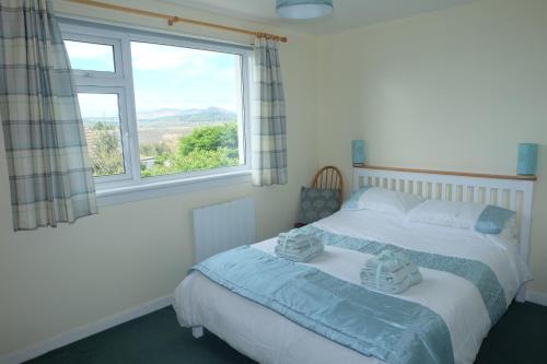 a bedroom with a bed and a window at Tir Nan Og in Rockcliffe