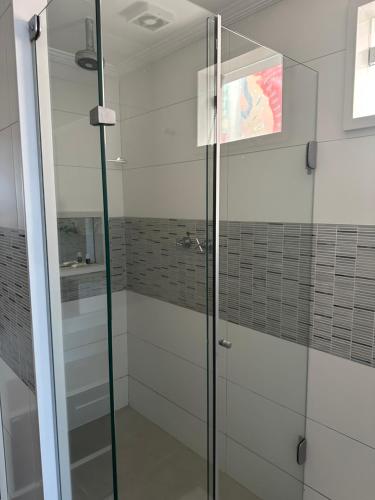 a shower with glass doors in a bathroom at Residência Angra Deep Blue in Angra dos Reis