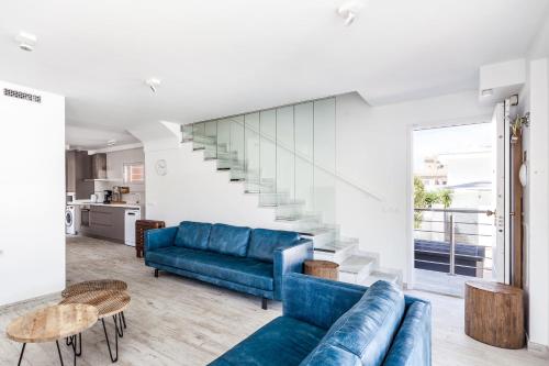 a living room with a blue couch and a staircase at Casa Bos Orange Wellness Luxury Entire Villa Jacuzzi & Pool Gran Alacant near Beach in Puerto Marino