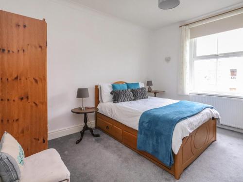 Un dormitorio con una cama grande y una ventana en Victoria Court, en Weymouth