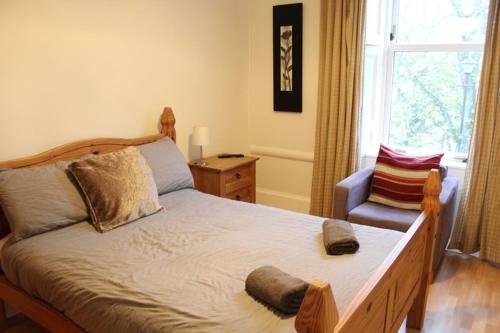 a bedroom with a bed with a chair and a window at Beautiful house on NC500 Route in Wick