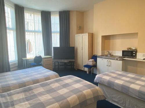 a hotel room with two beds and a tv at Athol House in South Shields