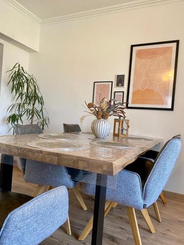 a dining room with a wooden table and blue chairs at Home Sweet Apartment XL in Bükfürdő