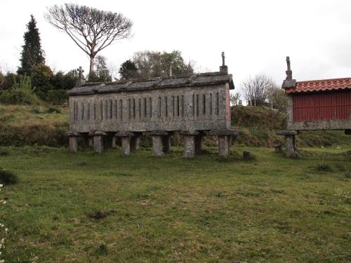 an old wooden building sitting in a field at Villa Rio in Tangil