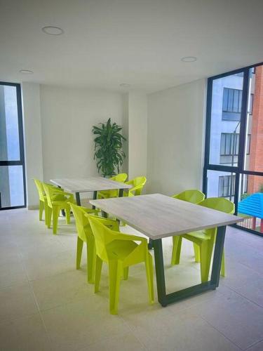 une rangée de tables et de chaises jaunes dans une pièce dans l'établissement Hermoso Apartamento 2 Habitaciones 1 Aire acondicionado, à Cartago