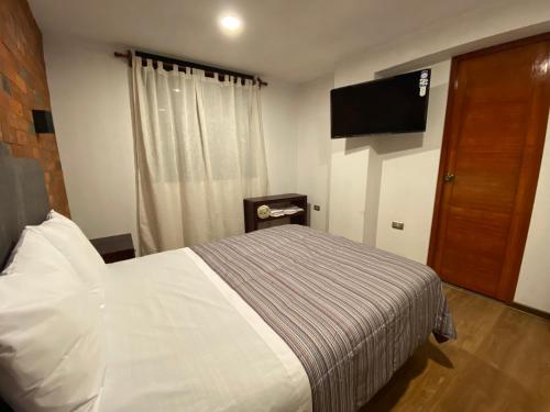 um quarto com uma cama e uma televisão de ecrã plano em Hotel Central Pacasmayo em Pacasmayo