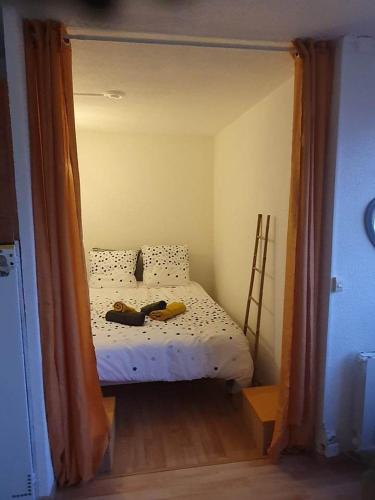 Cette petite chambre comprend un lit avec deux chaussures. dans l'établissement Appartement T2 27m² meublé, vue mer à 50m de la plage, à Narbonne-Plage