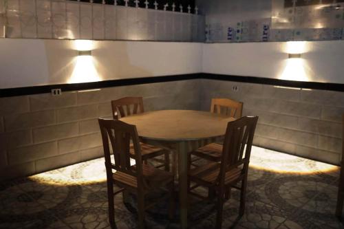a table and chairs in a room with lights at Happiness Guest House in Luxor