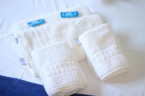 three white knitted towels sitting on a table at Hotel Mar Navegantes in Pinhal