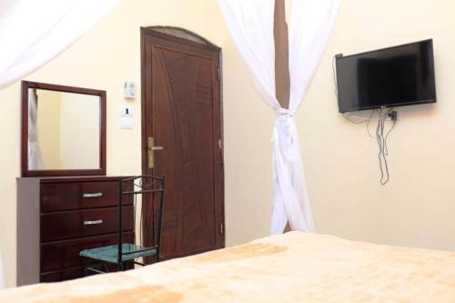 a bedroom with a bed and a dresser and a mirror at Happiness Guest House in Luxor