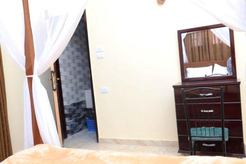 a bedroom with a mirror and a dresser and a dresser with a bed at Happiness Guest House in Luxor
