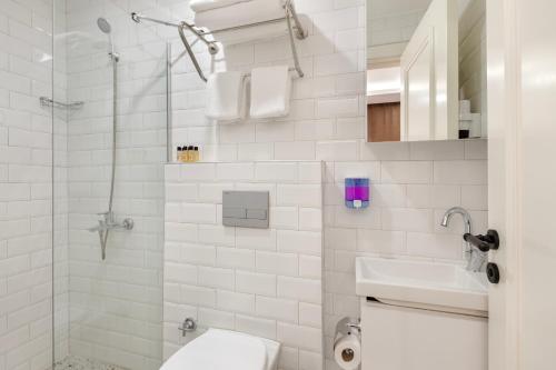 a white bathroom with a toilet and a sink at Perlo Hotel Kemer in Kemer