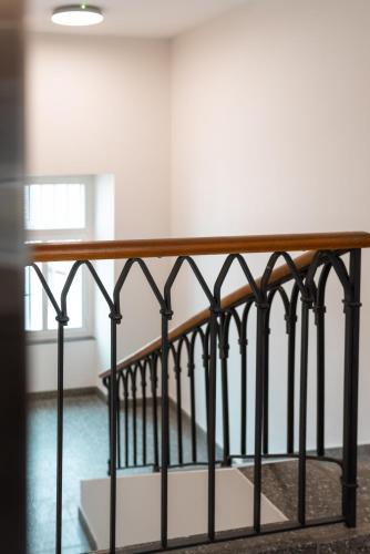 a railing in a room with a staircase at Bogentrakt Hostel in Chur
