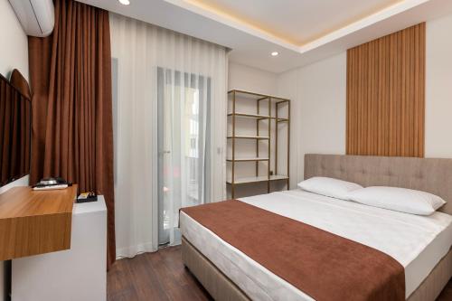 a bedroom with a large bed and a window at Perlo Hotel Kemer in Kemer