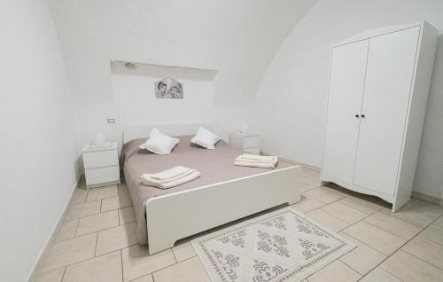a white bedroom with a bed and a white cabinet at La casa di mammina in Bari