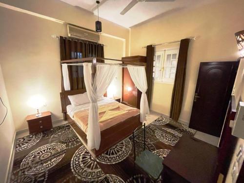 a bedroom with a bed with a canopy at Happiness Guest House in Luxor