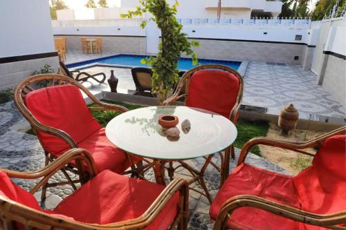 a patio with a table and chairs and a pool at Happiness Guest House in Luxor