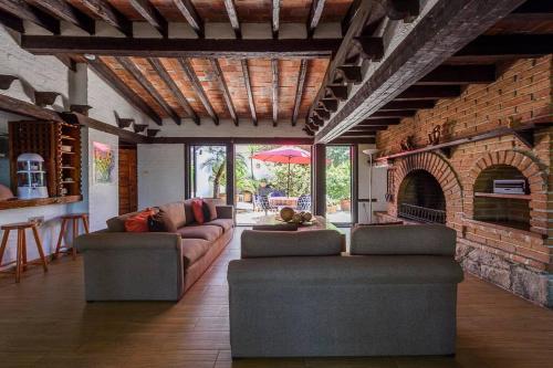 a living room with two couches and a brick fireplace at Increible Cuarto, Hostal Sobre el Centro de Valle in Valle de Bravo