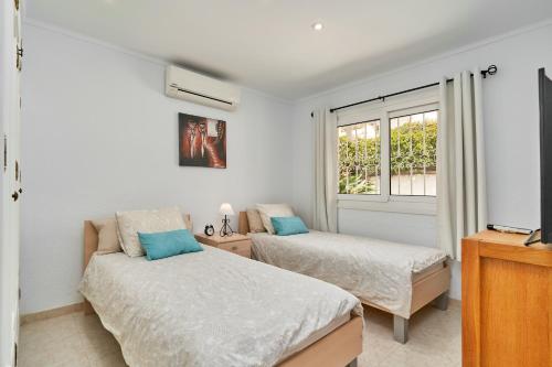a bedroom with two beds and a window at Casa Ambar in Nerja