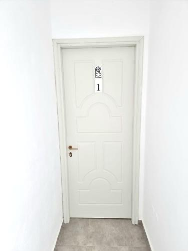 a white door with a sign on it at Joannes Vacation Rooms in Adamas
