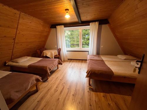 ズバルドンにあるAgroturystykaのベッド2台と窓が備わる客室です。