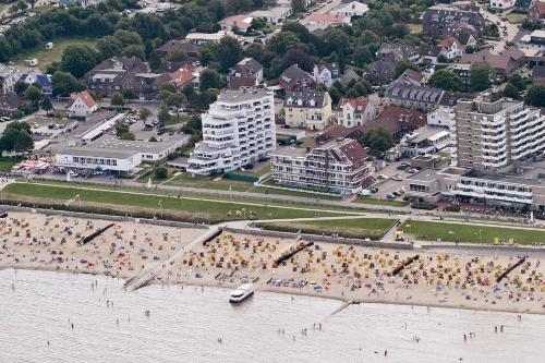 un groupe de personnes sur une plage près de l'eau dans l'établissement Haus Hanseatic, Wohnung 312, à Duhnen