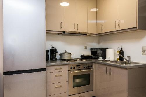 a kitchen with white cabinets and a stove top oven at Avyssos Residents in Kalamaki