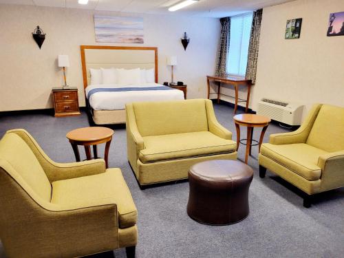 a hotel room with a bed and chairs at Bangor Grande Hotel in Bangor