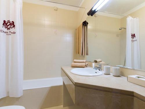ein Badezimmer mit einem Waschbecken, einer Dusche und einer Badewanne in der Unterkunft Dom Pedro Portobelo in Vilamoura