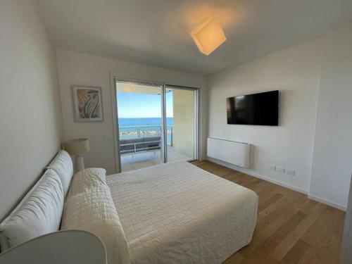 a bedroom with a bed and a couch and a television at Gli Scogli Luxury Residence Hotel in Chiavari