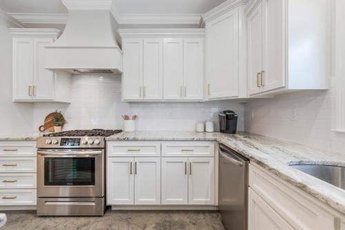 a kitchen with white cabinets and a stainless steel oven at Charming Cottage built in 2019 in Lafayette