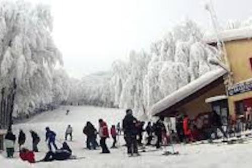 un grupo de personas de pie en la nieve cerca de un lodge de esquí en Casa di Adele, en Pratovecchio