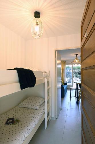 - une chambre avec des lits superposés et une salle à manger dans l'établissement Charmant studio 2à4 pers avec jardin et place de parking situé à 5 min à pied de la mer, à Bandol