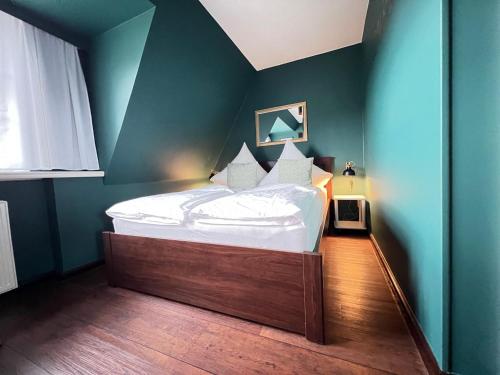 um quarto com uma cama grande num quarto azul em Strandmuschel em List